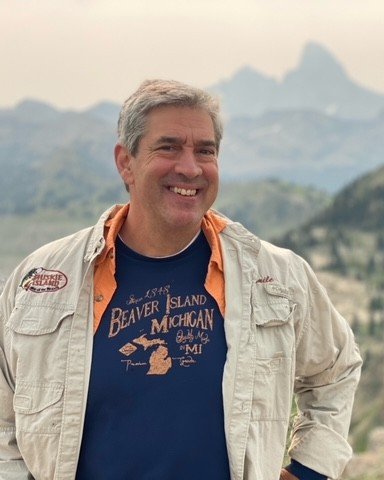 Emile Smith, smiling, with mountains rising behind him.