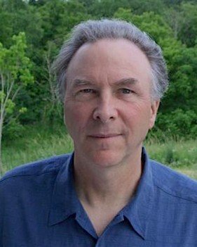 Rob Danielson, in a blue shirt, with Driftless woods behind him.