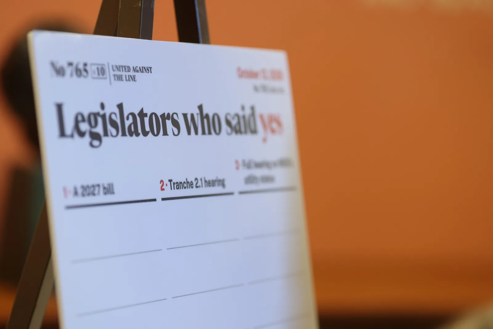 Photo 1 of 34. An easel sign reading Legislators who said yes, with a column for each of the three requests, set up for the morning.
