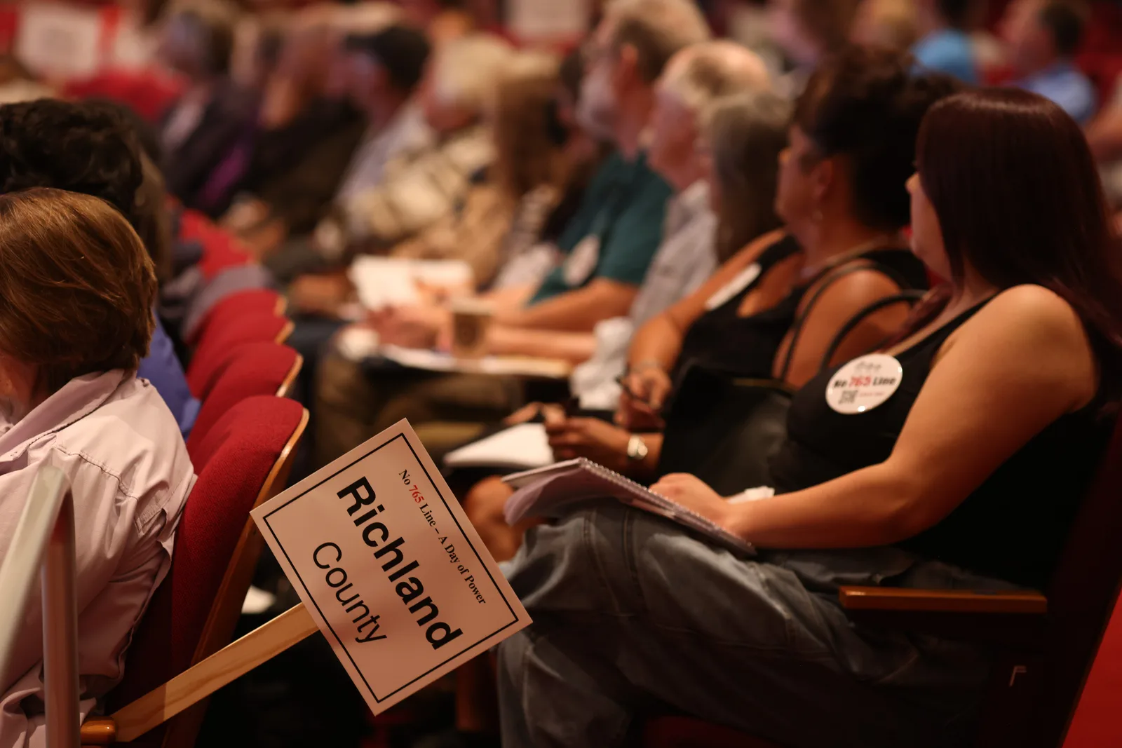 Photo 3 of 34. A Richland County sign among residents seated in the Lecture Hall at Monona Terrace.