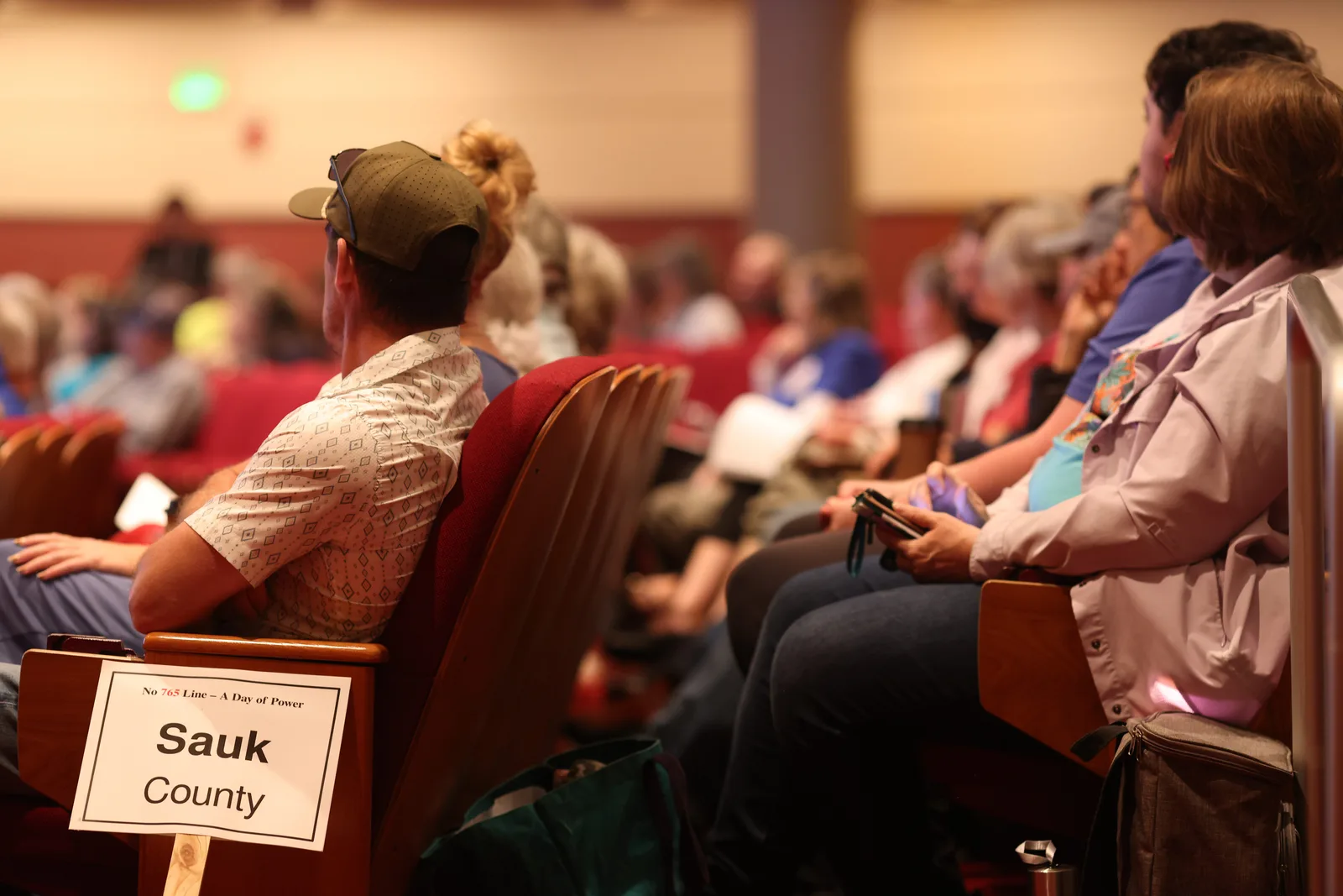 Photo 4 of 34. A Sauk County sign among residents seated in the Lecture Hall.