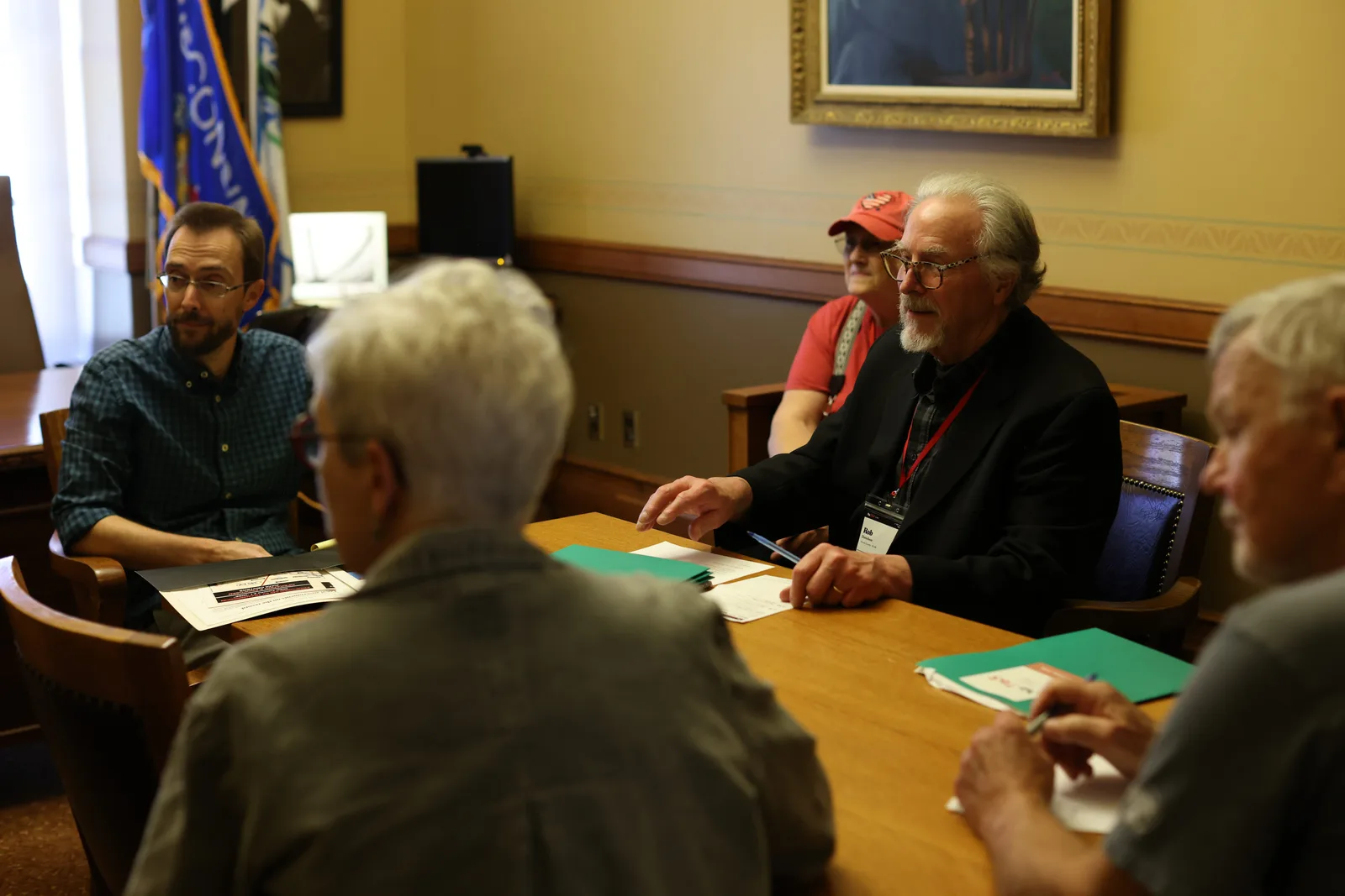 Photo 12 of 34. Residents meet with a legislative staffer around an office table.