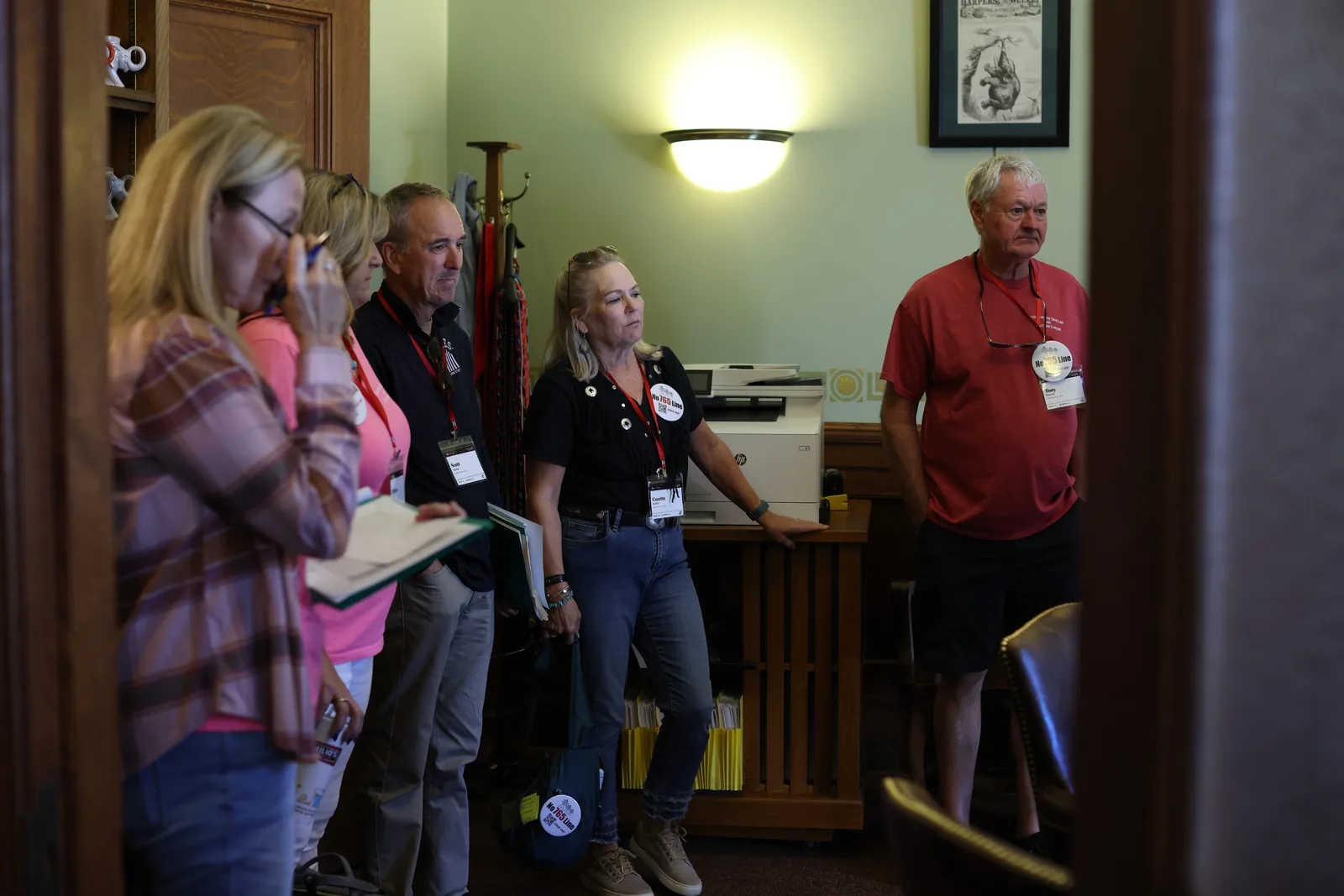 Photo 16 of 34. A team waits in the doorway of a legislator's office.