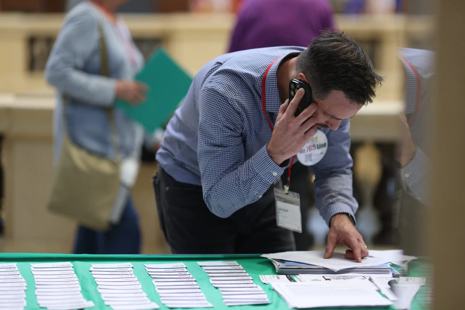 Photo 22 of 34. A volunteer takes a call over the sign-in table.