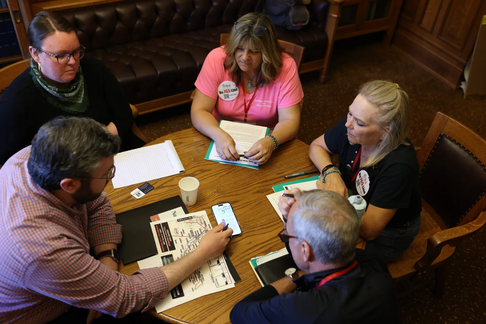 Photo 23 of 34. Residents go over maps with staff at an office table.