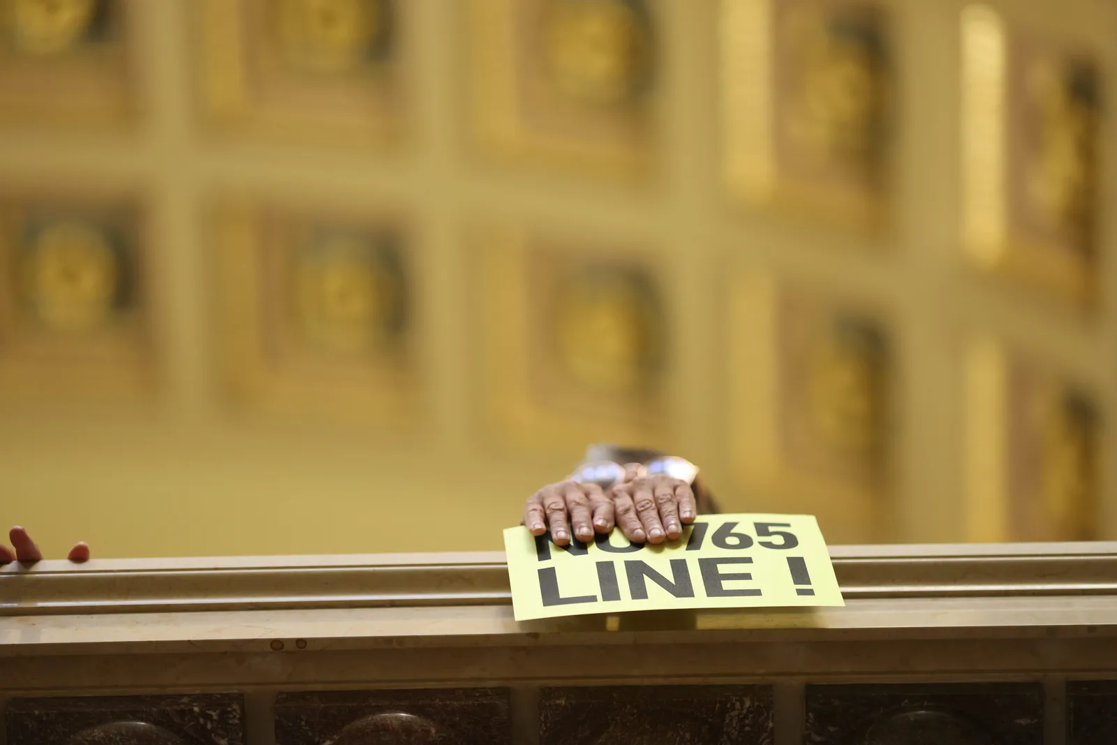 Photo 31 of 34. A hand on the Rotunda railing holds a No 765 Line sign.