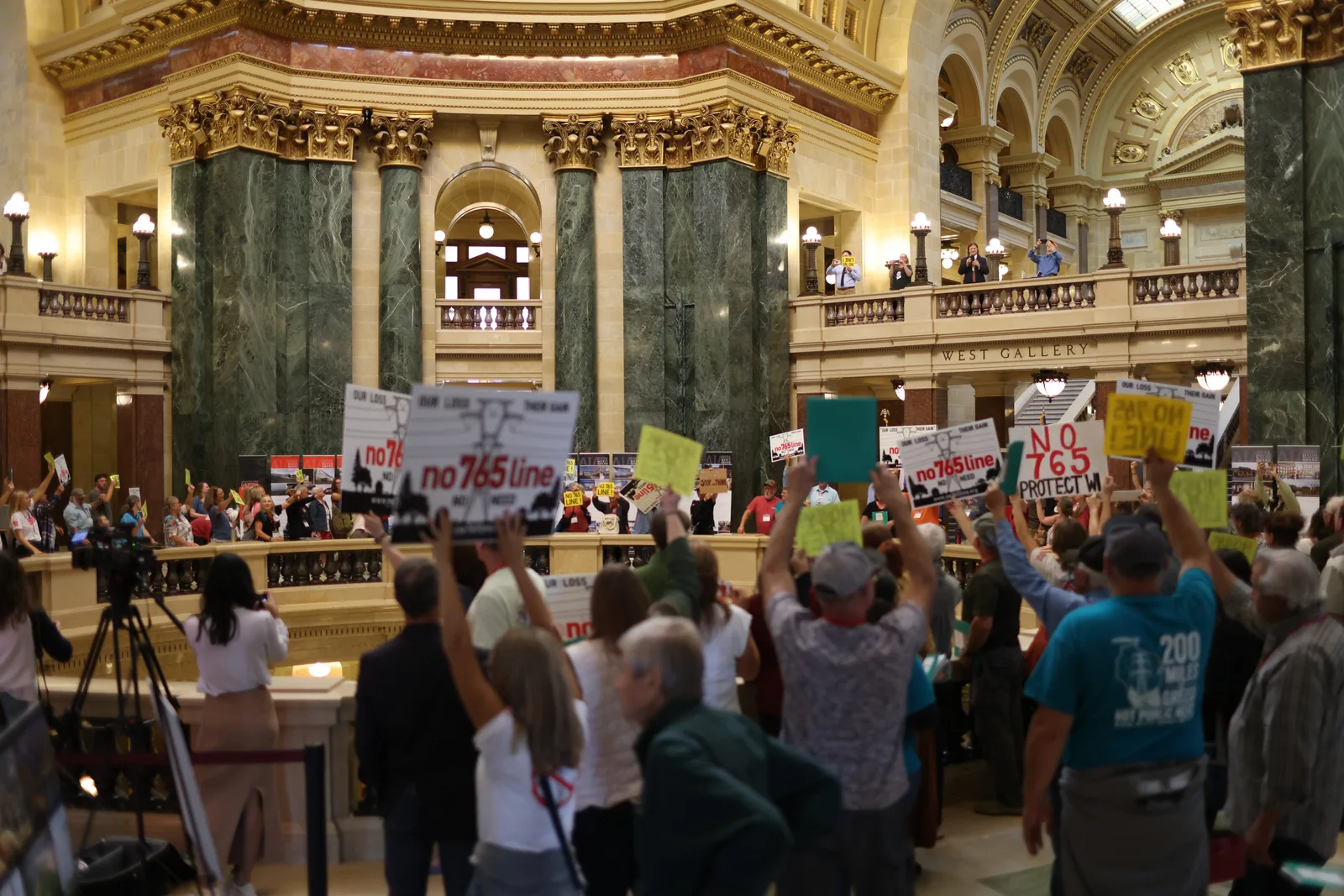 Photo 34 of 34. Residents raise their signs in the Capitol Rotunda.