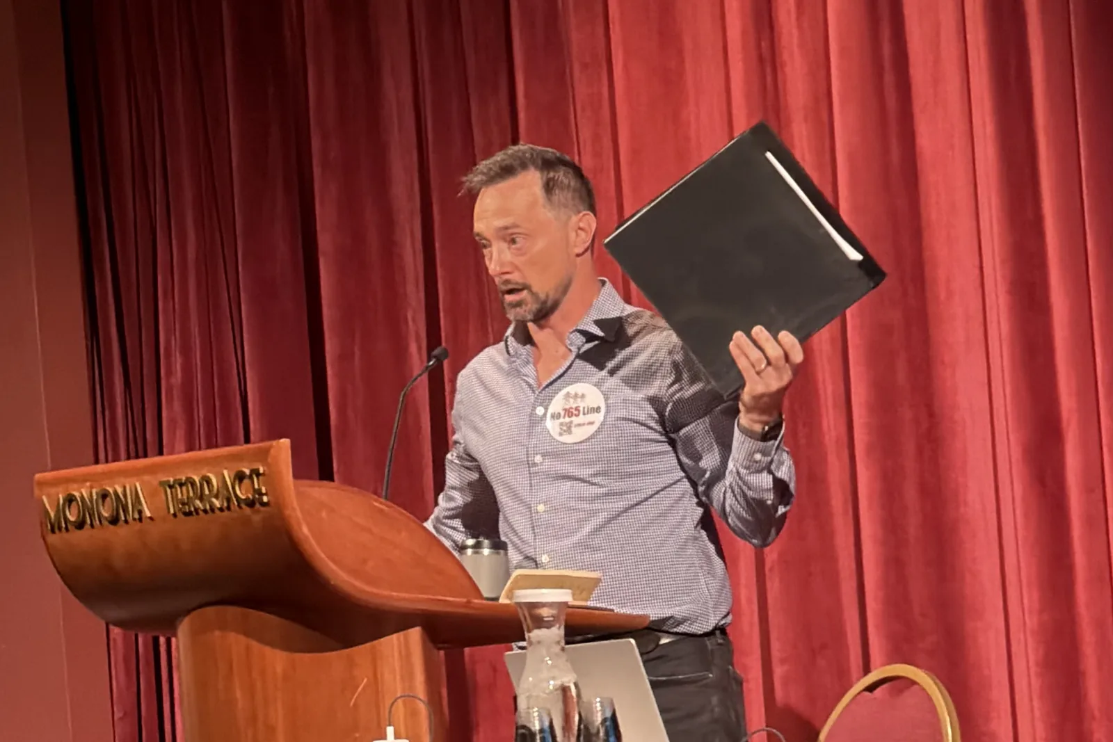 Photo 7 of 34. An organizer holds up the office packet during the morning session at Monona Terrace.